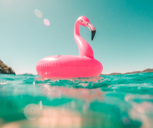 Vacaciones de veranos 2019: flamenco rosa hinchable en el mar.