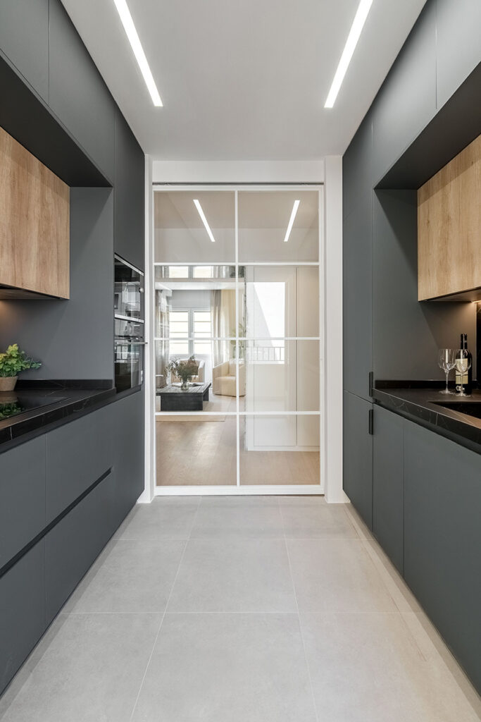 Puertas correderas de hierro y cristal que dan entrada a la cocina. ALEM Arquitectura