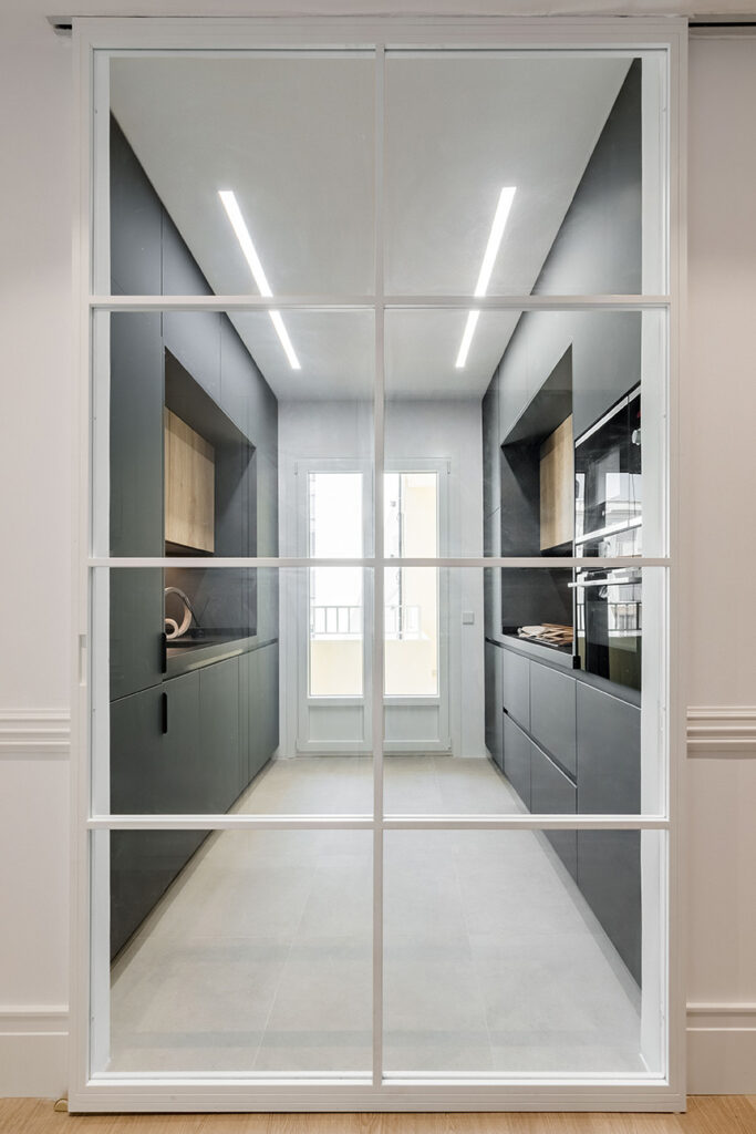ALEM Arquitectura. Puertas correderas de hierro y cristal que dan entrada a la cocina.