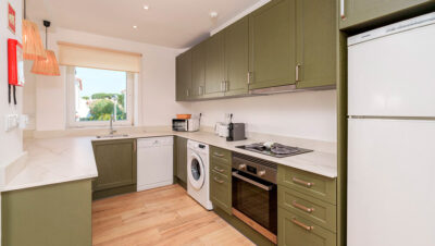 Cocina moderna verde oliva con isla central y estilo natural