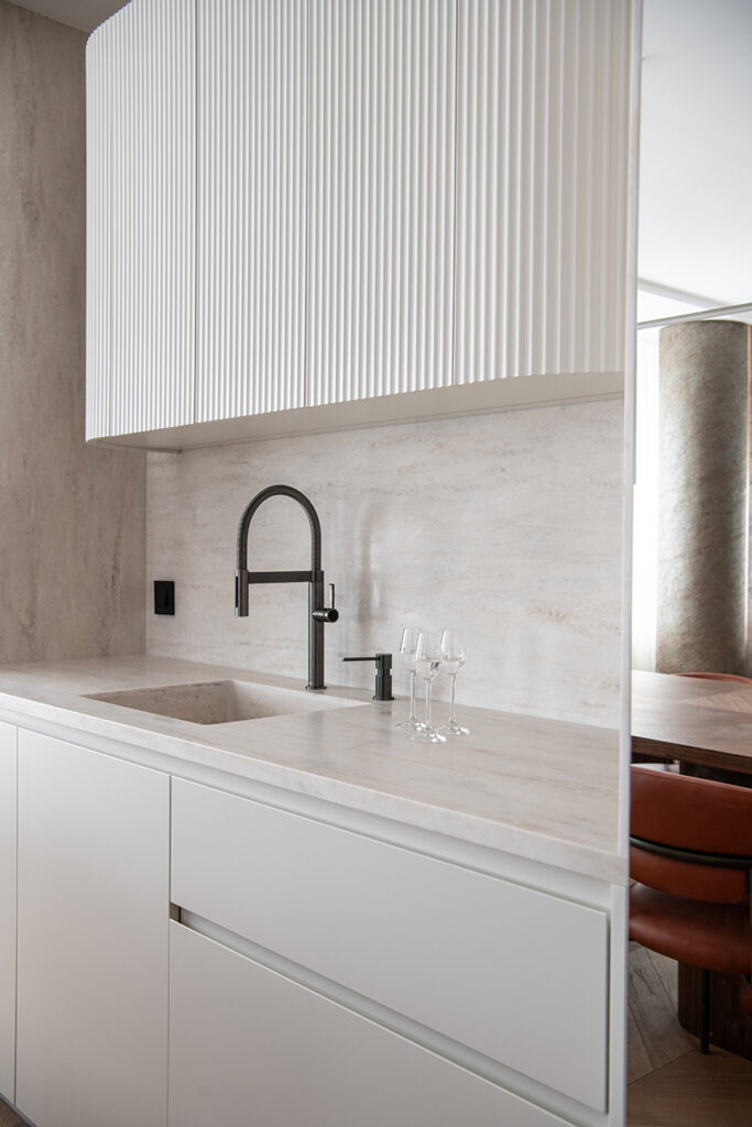 Interior contemporáneo con superficies continuas HIMACS y acabados cálidos