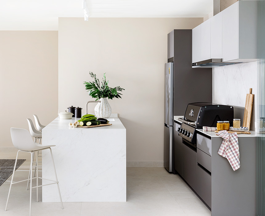 Cocina exterior con isla central y zona de reuniones.