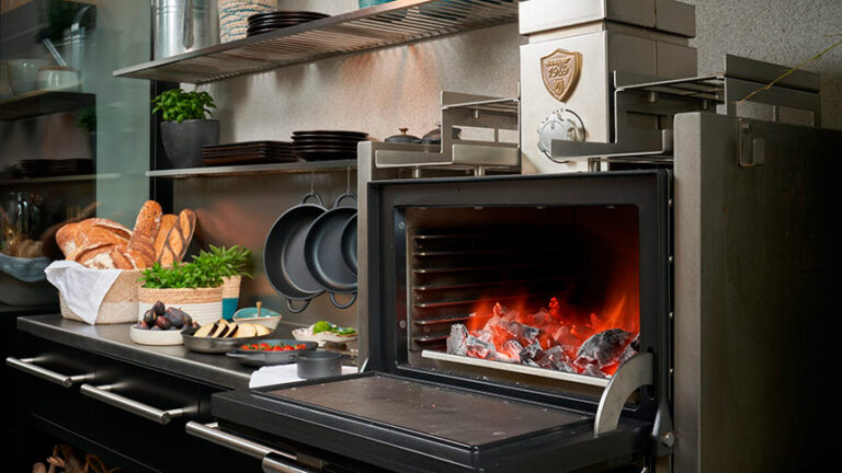 Horno de brasa JOSPER HJX-15 instalado en una cocina outdoor con diseño contemporáneo para terrazas y jardines.